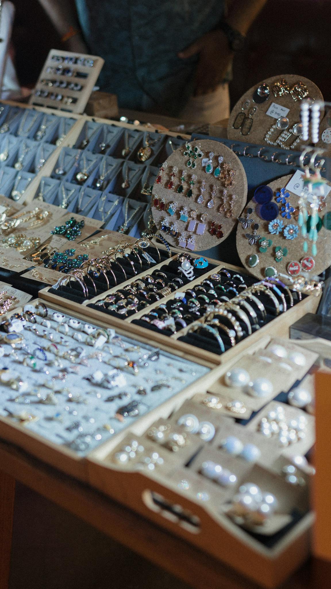 A close-up of a jewelry display showcasing a variety of handcrafted earrings and rings.
