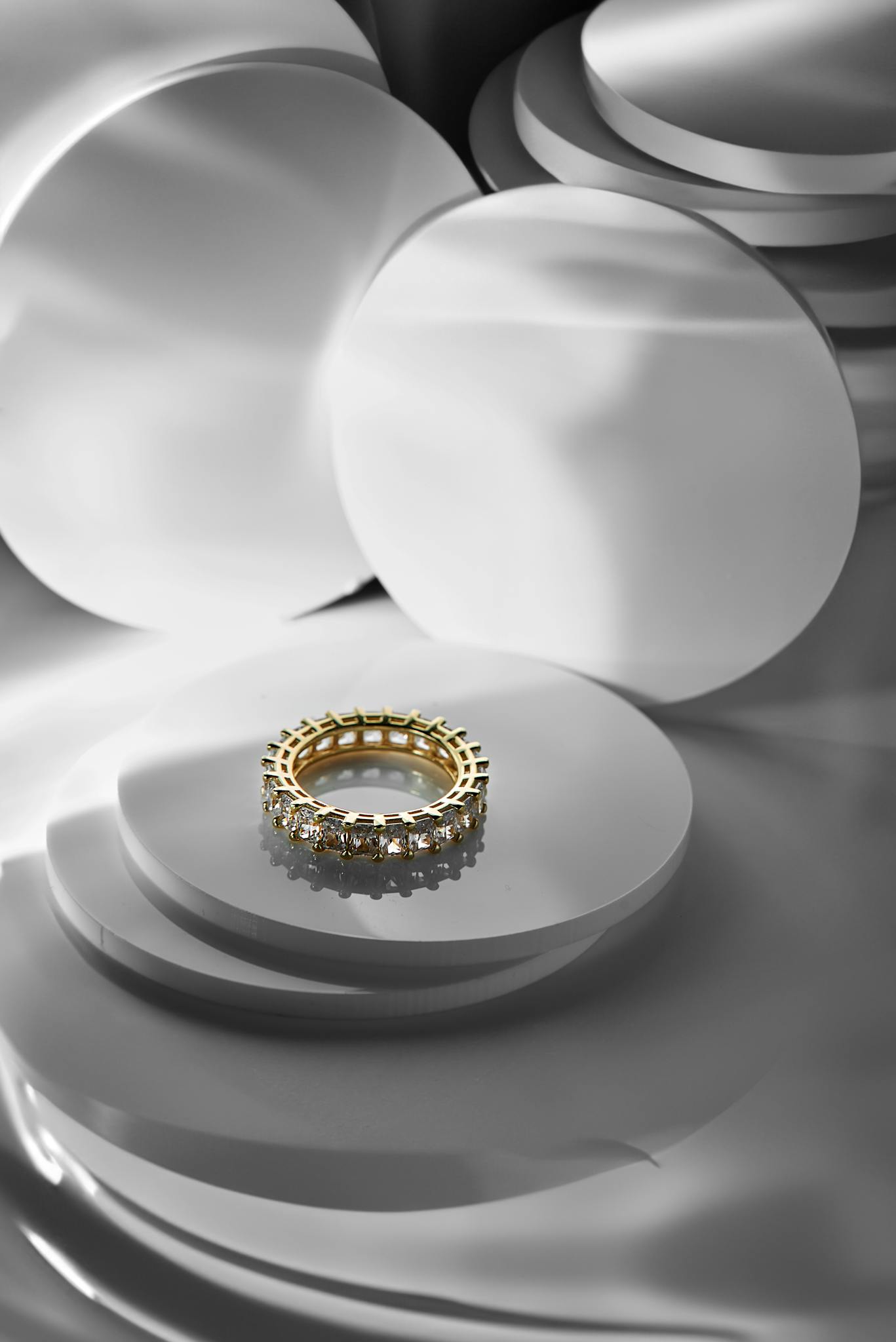 A luxurious diamond and gold ring displayed against a sleek, modern abstract background.