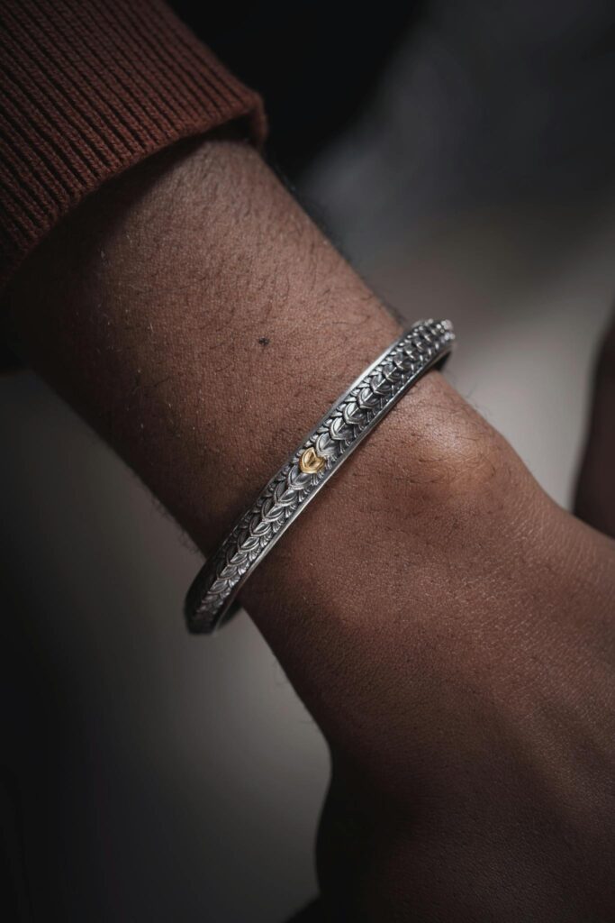 Close-up of a stylish silver bracelet showcasing intricate design on a wrist.