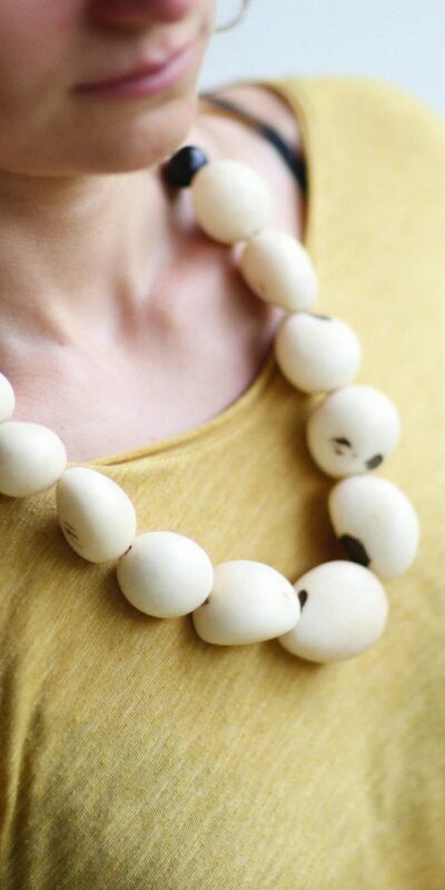Close-up of a woman wearing a bold necklace with large beads.