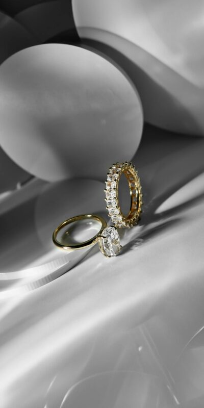 Close-up of two elegant gold and diamond rings in a minimalist setting, showcasing luxury and sophistication.