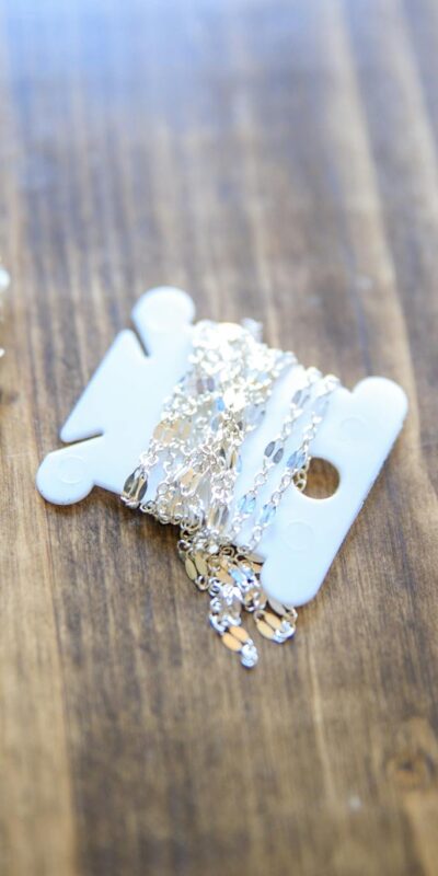 Detailed view of handmade jewelry pieces on a rustic wooden tabletop, emphasizing creativity and craftsmanship.